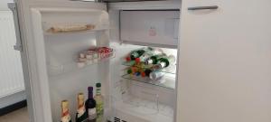einen offenen Kühlschrank mit Flaschen und Getränken in der Unterkunft Ferienwohnung in Großostheim