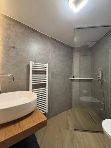 Un baño con bañera blanca y lavabo. en Diamanti Residence Beachside White apt-Ligaria, en Ligaria
