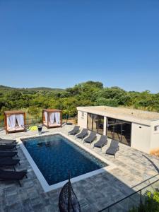 a swimming pool with lounge chairs and a house at Villa JaNi in Donja Jagodnja