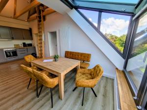 a kitchen and dining room with a wooden table and chairs at Etzel-Lodge Weideblick in Friedeburg