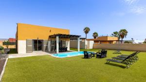 a backyard with a swimming pool and a house at Villa Calima by Calima Villas in Costa de Antigua