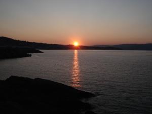 a sunset over a large body of water at Hotel Siroco Portonovo in Sanxenxo