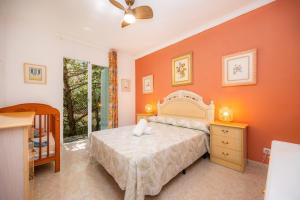 a bedroom with a bed with an orange wall at Ca'n Miquel in Colonia de Sant Pere