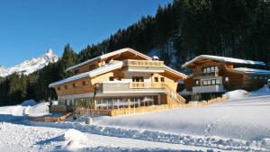 a wooden house in the snow with snow covered ground at Alpin Chalet Filzmoos in Filzmoos