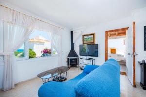 a living room with a blue couch and a tv at Ca'n Miquel in Colonia de Sant Pere