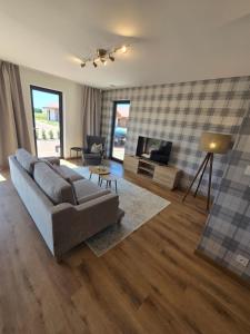 een woonkamer met een bank en een televisie bij Eko Osada Zacisze in Ostrowite