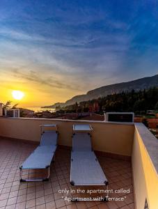 two benches sitting on a balcony with the sunset at La Cà del Picia in Garda