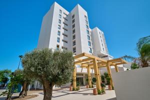 a large white building with trees in front of it at Hipotels Don Juan in Cala Millor