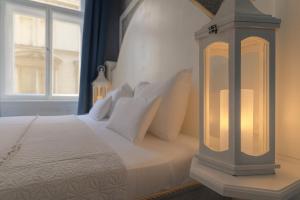 une chambre avec un lit blanc avec une grande fenêtre dans l'établissement Royal Prague City Apartments, à Prague