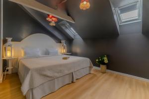 une chambre avec un grand lit dans un grenier dans l'établissement Royal Prague City Apartments, à Prague