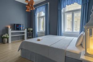 una camera da letto con un letto con pareti e finestre blu di Royal Prague City Apartments a Praga Altre 86 foto