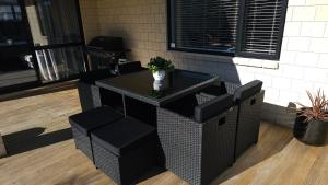 a bar with black chairs and a table with a plant at 10 @ Wai Matangi in Turangi