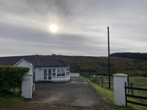 a white house with a fence and a driveway at Glengesh House in Barr