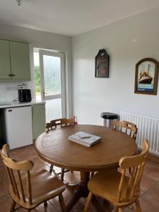 a dining room with a wooden table and chairs at Glengesh House in Barr +6 photos