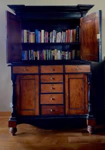 a wooden cabinet with books on top of it at Atulya Villas Nuwara Eliya in Nuwara Eliya