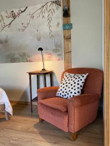 a orange chair with a pillow on a table at Katies Tiny House in Budapest