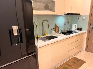 a small kitchen with a sink and a refrigerator at Vinhome Grand Park Homestay-ZEN Garden House in Long Bình +42 photos
