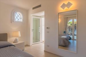 a bedroom with a bed and a large mirror at Villetta La Conia in Cannigione +29 photos