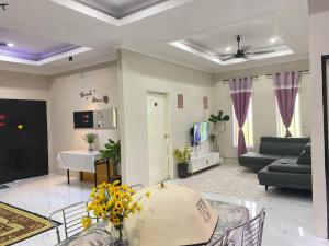 a living room with a table and a couch at Teratak D' Chemumaq Arau in Arau
