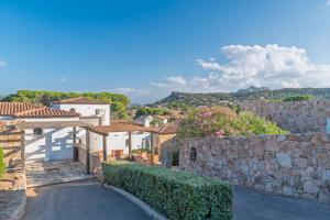 a house with a stone wall and a street at Villetta La Conia in Cannigione