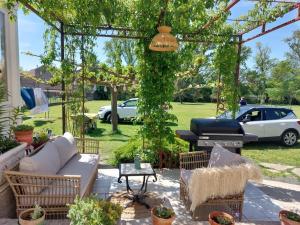 a pergola with a grill in a yard at La cazabanelle in Villegly