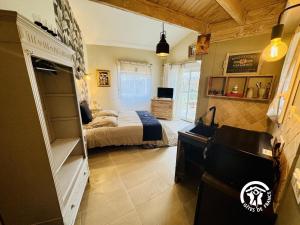 a bedroom with a bed and a desk in a room at La cazabanelle in Villegly +24 photos