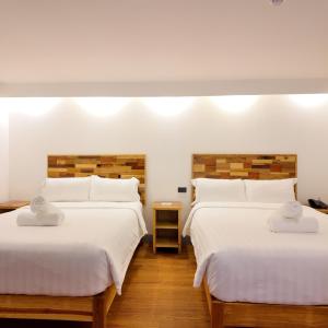 two beds in a room with white sheets at El Puerto Boracay Shore in Boracay +34 photos