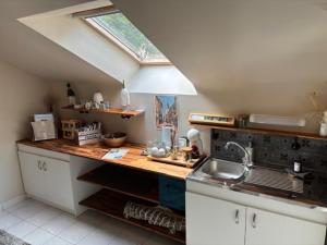 a kitchen with a counter with a sink and a window at La Maison des Cordiers in Dinan