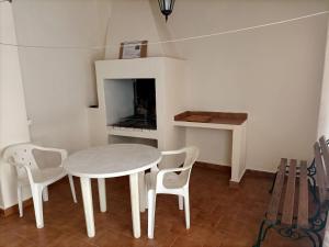 a white table and chairs in a room with a fireplace at Casa Fuenteblanca in Liétor