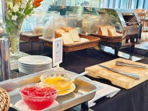 a buffet with a tray of bread and baskets of food at Buritel Hotel in Buriram