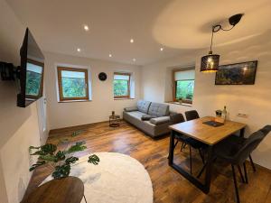 a living room with a table and a couch at Modernes Serviced Apartment - FeWo Land Idyll in Dürrnberg