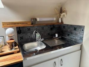 a kitchen with a sink and a counter top at La Maison des Cordiers in Dinan