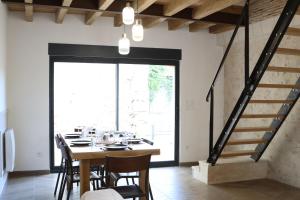 a dining room with a table and chairs and a staircase at Gîte de L'Atelier in Mont-près-Chambord