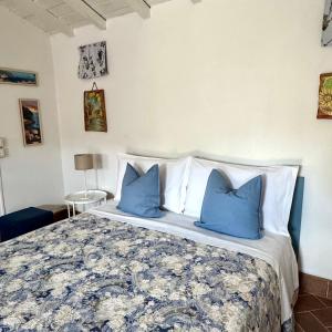 a bedroom with a large bed with blue pillows at Appartamento Cà Insulae in Luni