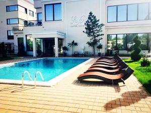 a swimming pool in front of a building at La Rocca Boutique Hotel in Craiova