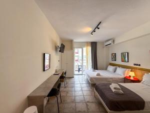 a hotel room with two beds and a table at Seagull apartments - Building A in Paralia Katerinis