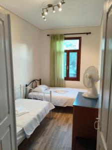 a room with two beds and a fan in it at V House Cozy & Quiet Escape in Mytilene