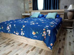 a bed with a blue comforter and blue pillows at Ingna Resort in Chanuman