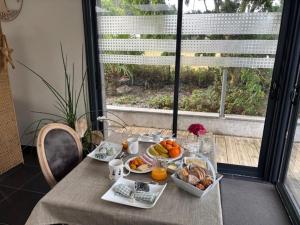 un tavolo con cibo per la colazione sopra e una finestra di La Maison des Cordiers a Dinan Altre 22 foto