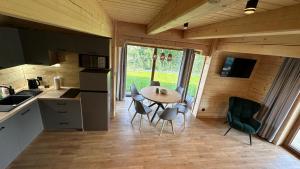 a kitchen with a table and chairs in a tiny house at Osada Widokowa Rymanów Zdrój in Rymanów-Zdrój