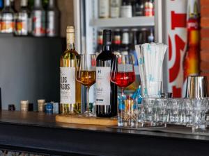 three bottles of wine sitting on a bar with glasses at CHECK inn Phnom Penh Royal Palace in Phnom Penh