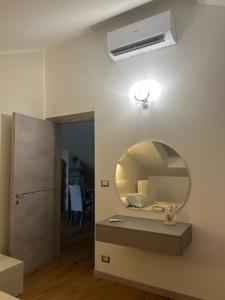 Una habitación con un espejo en la pared con una cama. en Maison di Pino, en Pino Torinese