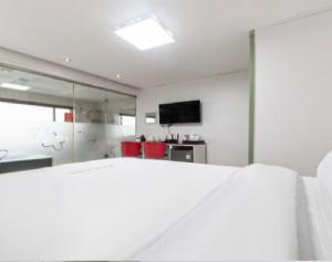 a white room with a bed and a television at Star Spa Hotel in Haenam