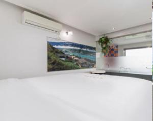 a bathroom with a sink and a painting on the wall at Star Spa Hotel in Haenam