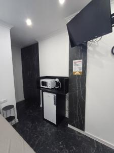 a small kitchen with a microwave on a counter at Casa Noa in Marginea +3 photos