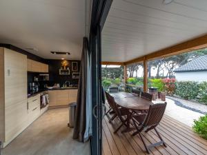 a wooden deck with a wooden table and chairs at Chalet 3 chambres avec piscines chauffées et accès plage à 9km - FR-1-783-24 in Pomérols
