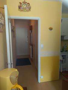 Un pasillo que conduce a una cocina con una pared amarilla. en Mon Petit Canada, en Mittlach