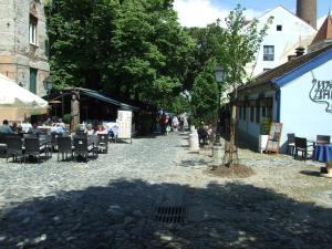 eine Straße mit Tischen und Stühlen und Menschen, die an Tischen sitzen in der Unterkunft Enjoy Belgrade in Belgrad