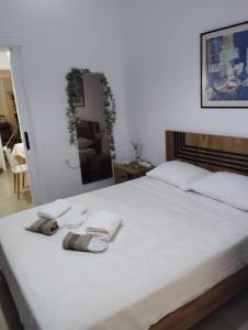Un dormitorio con una cama blanca con toallas. en Zizi's home, en Alexandroupoli