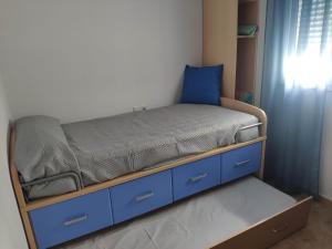 Una cama en una habitación con cajones azules y un colchón. en Casa turística AZAHAR, en Villablanca
